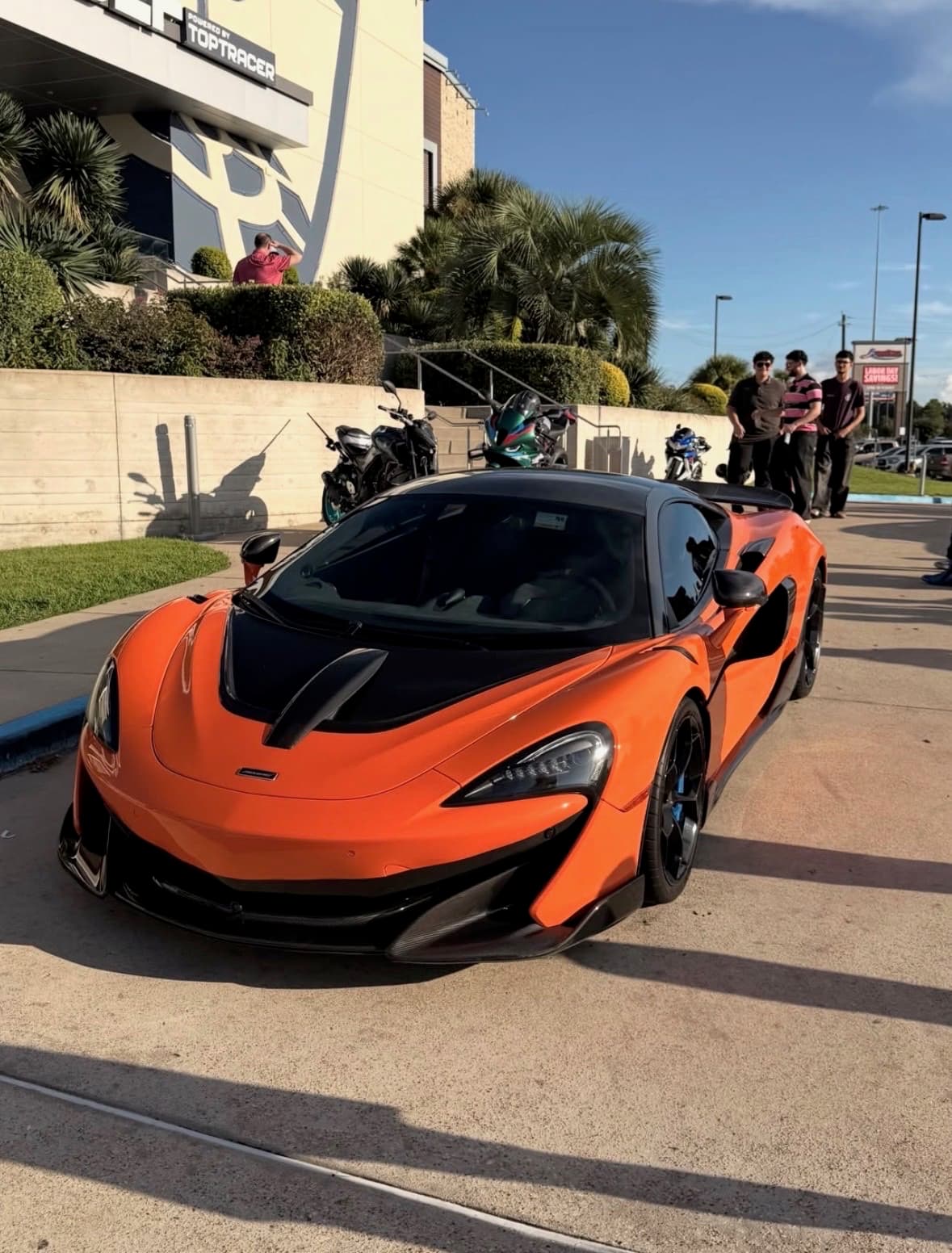 Orange McLaren 600LT parked near the Topgolf entrance
